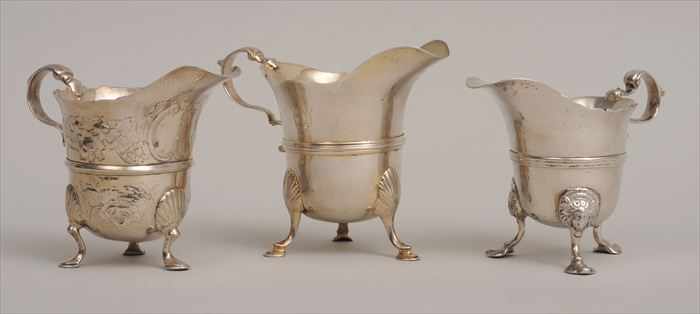 Appraisal: IRISH GEORGE II ARMORIAL SILVER HELMET-FORM TRIPOD CREAMER AND TWO