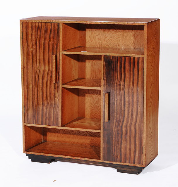 Appraisal: A HEALS OAK ASYMMETRICAL BOOKCASE with two cupboard sections two