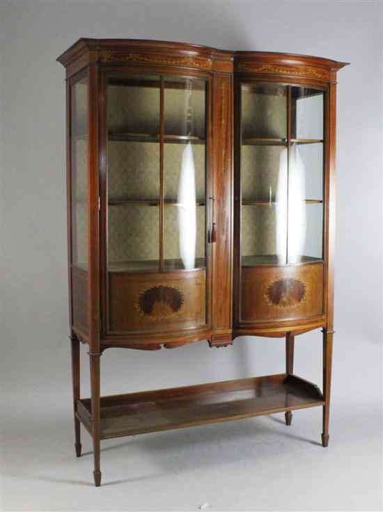 Appraisal: An Edwardian inlaid mahogany display cabinet with two bowfront doors