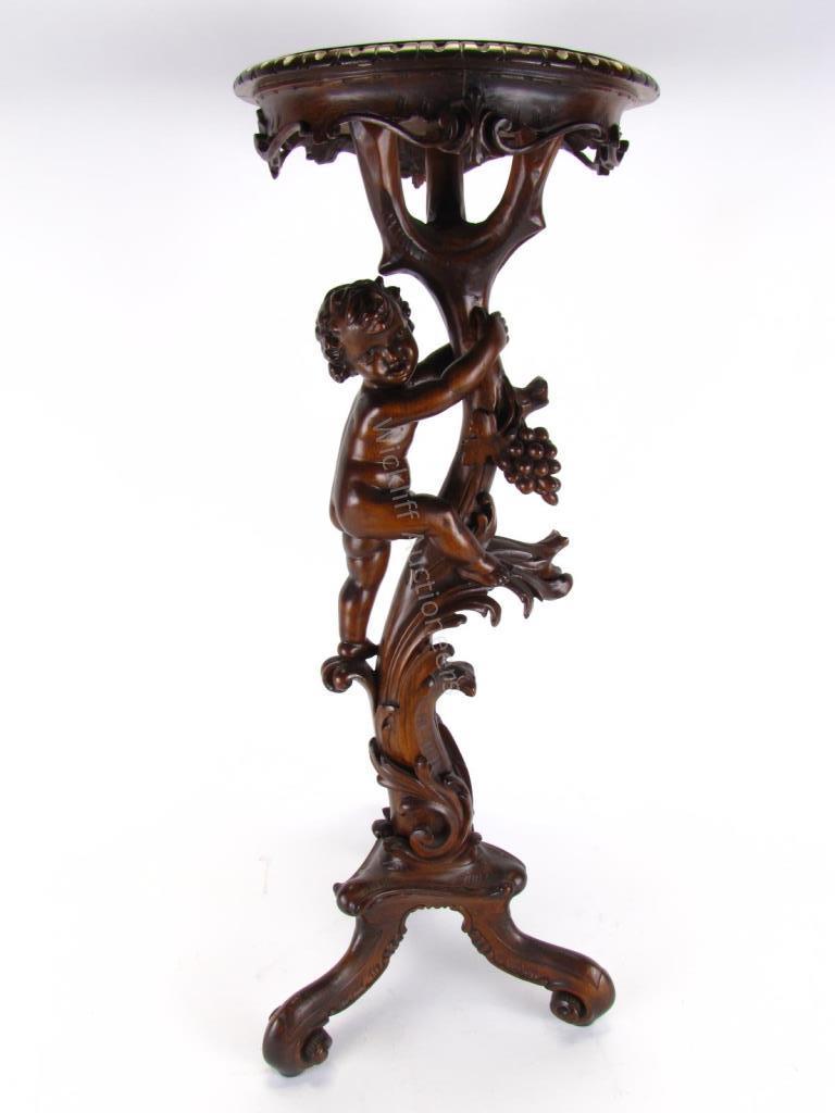 Appraisal: An antique mahogany plant stand with putto and grape carving