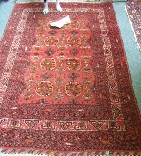 Appraisal: A modern Afghan style rug the madder field with two