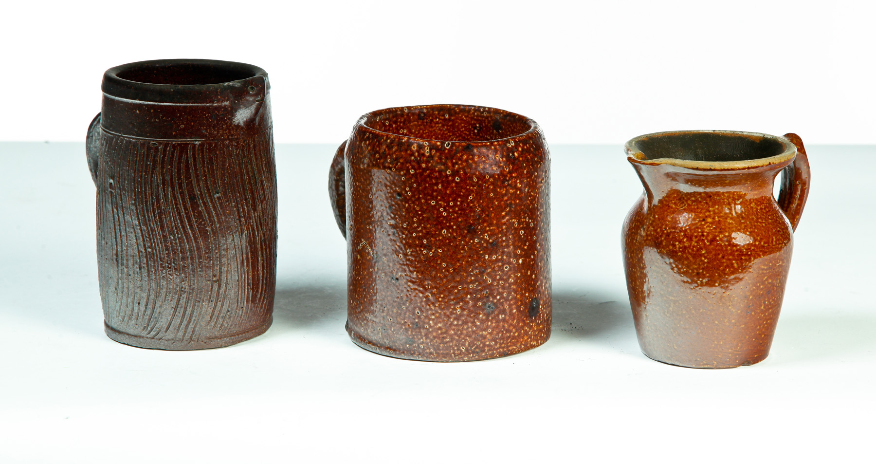 Appraisal: TWO AMERICAN SEWERTILE PITCHERS AND A MUG First half- th