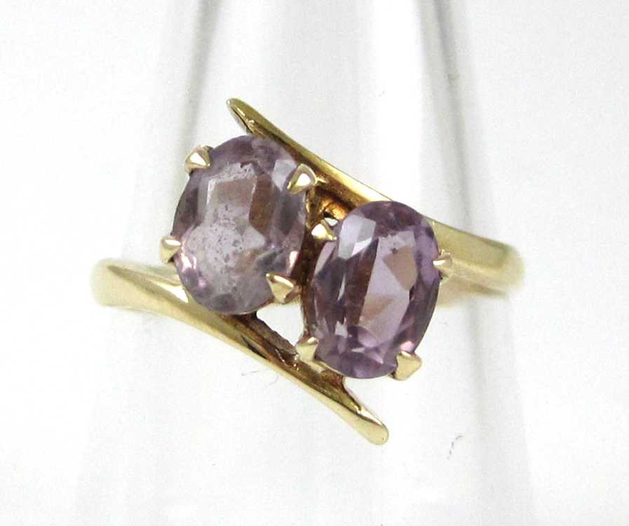 Appraisal: AMETHYST AND NINE KARAT GOLD RING set with two oval-cut