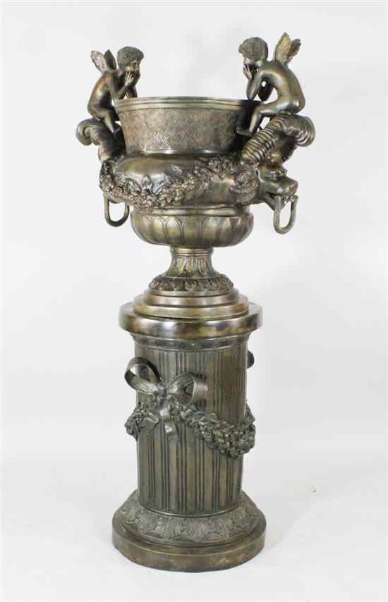 Appraisal: A large bronze twin handled urn modelled with cherubs on