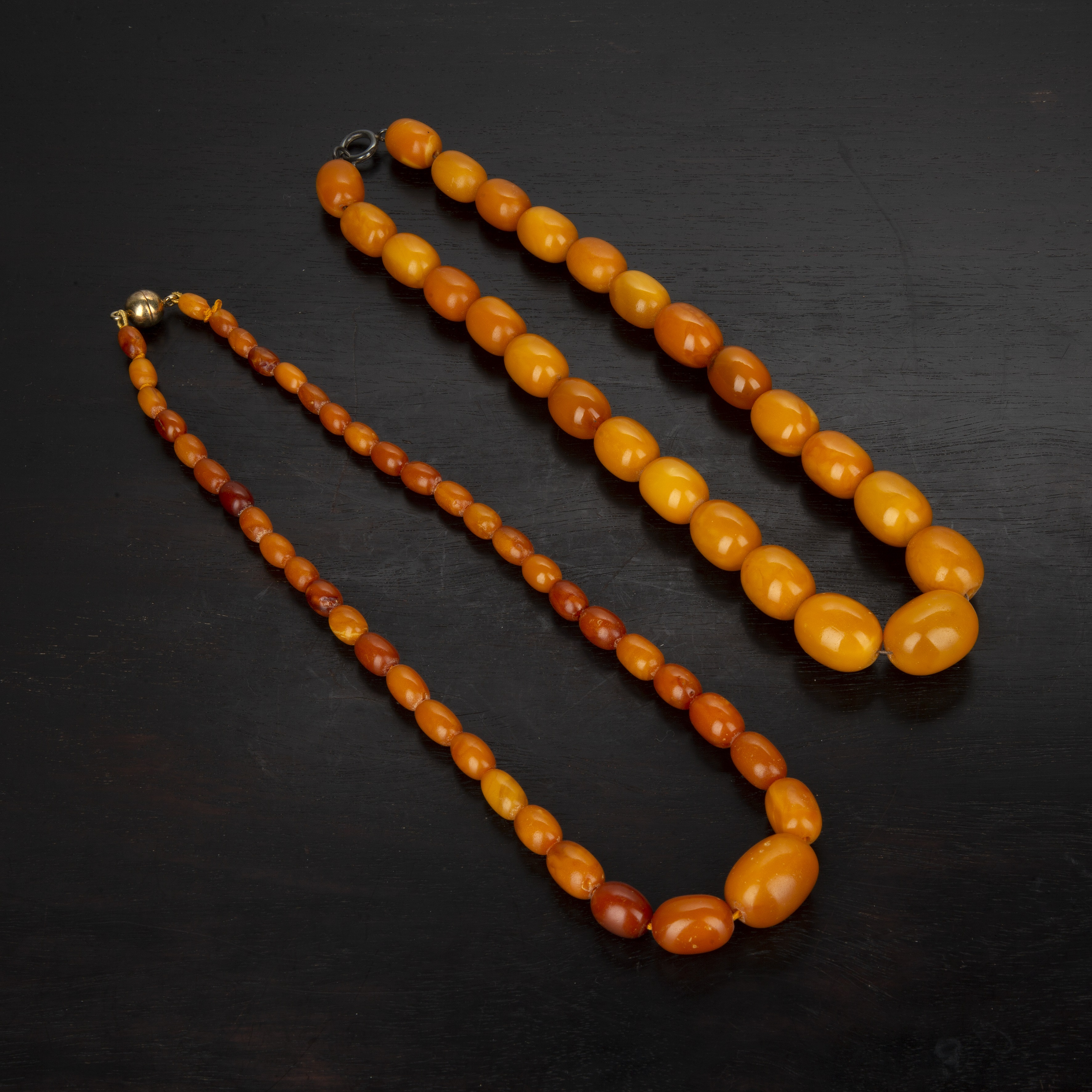 Appraisal: Two amber bead necklacesboth of graduated form the larger bead