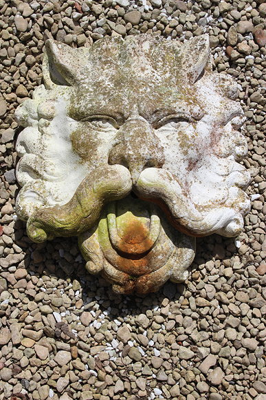 Appraisal: A CONCRETE WALL MASK of a moustachioed devil cm high