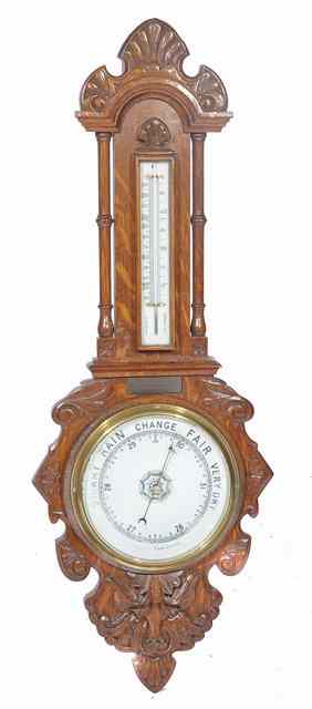 Appraisal: A CARVED OAK CASED BANJO ANEROID BAROMETER AND THERMOMETER presented