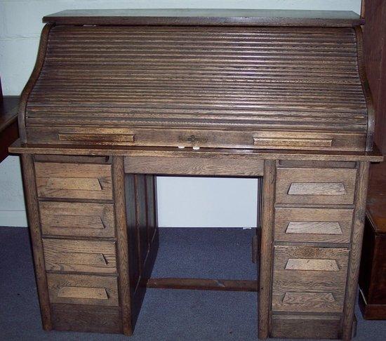 Appraisal: An oak roll top desk fitted beneath the tambour with