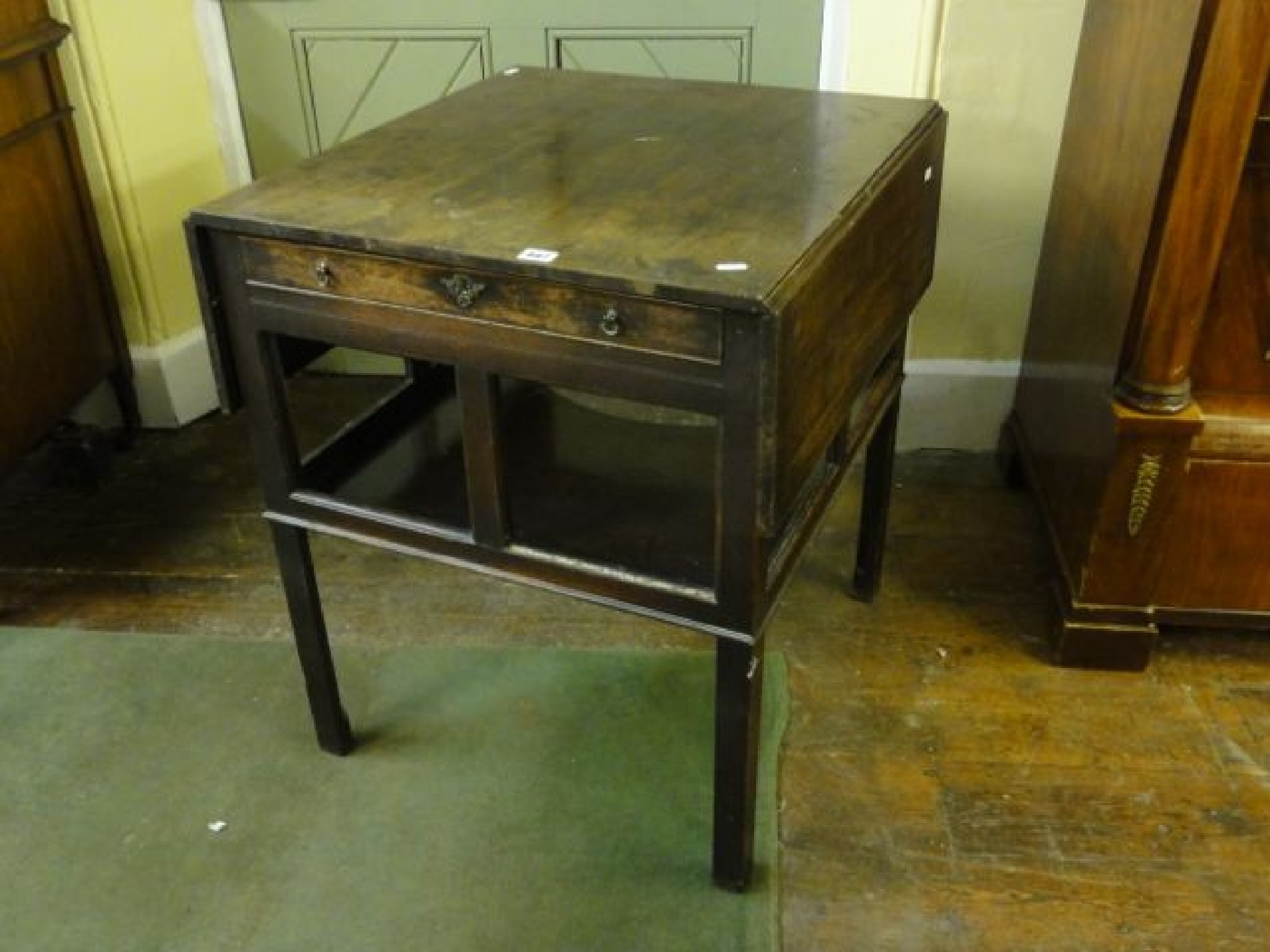 Appraisal: A Georgian mahogany drop-leaf occasional table with open framework below