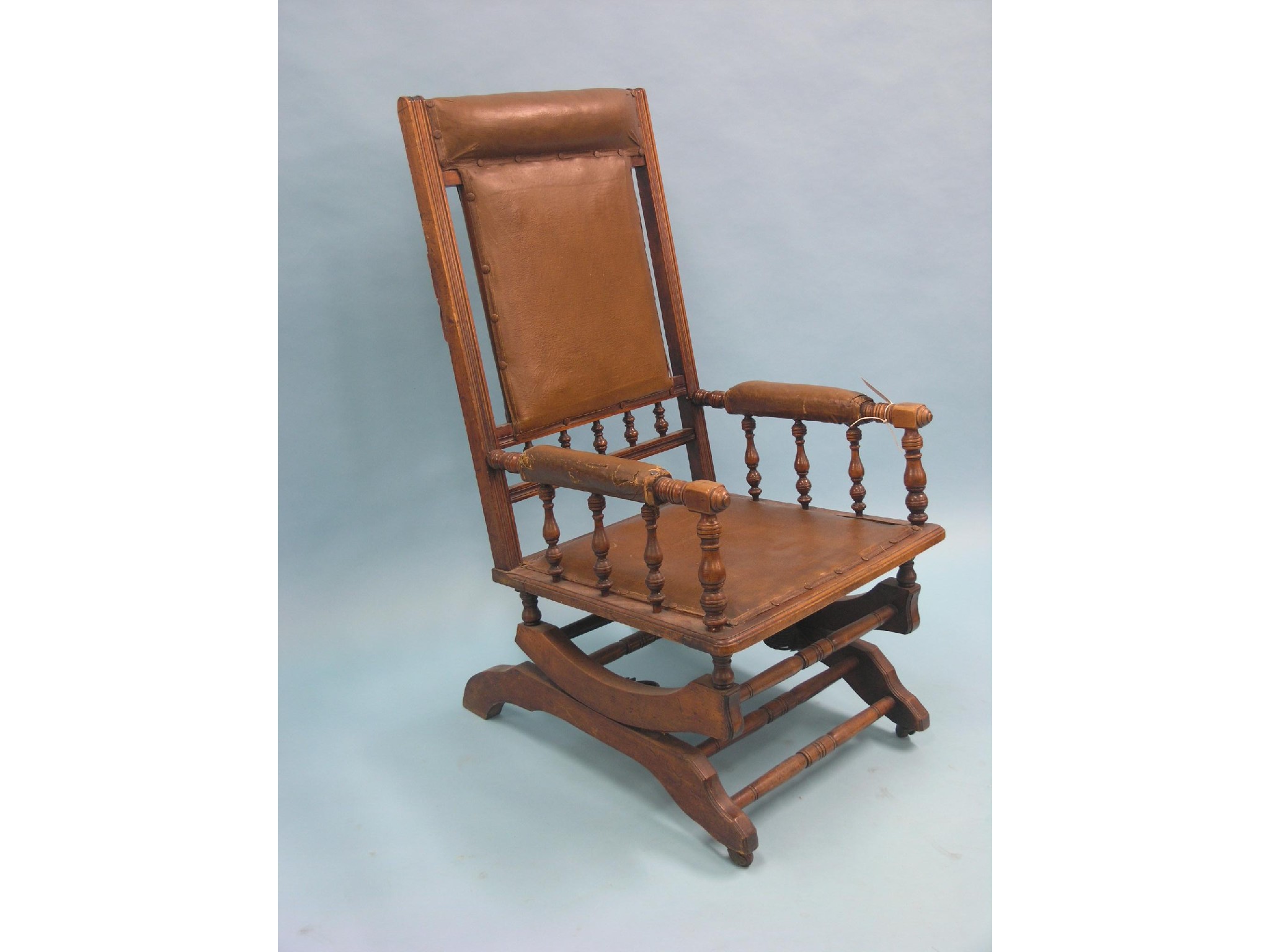 Appraisal: A late Victorian walnut rocking armchair spindle-turned frame with padded