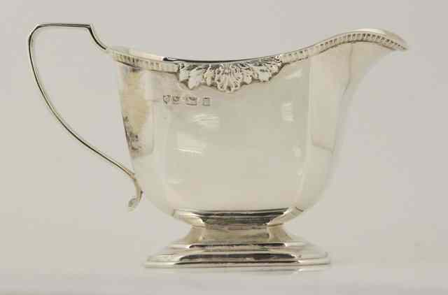 Appraisal: A silver cream jug Birmingham with gadrooned leaf rim approximately