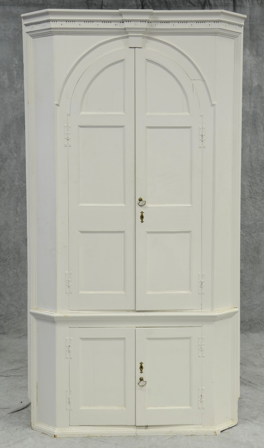 Appraisal: One-piece pine barrel-back corner cupboard complex chip carved cornice with