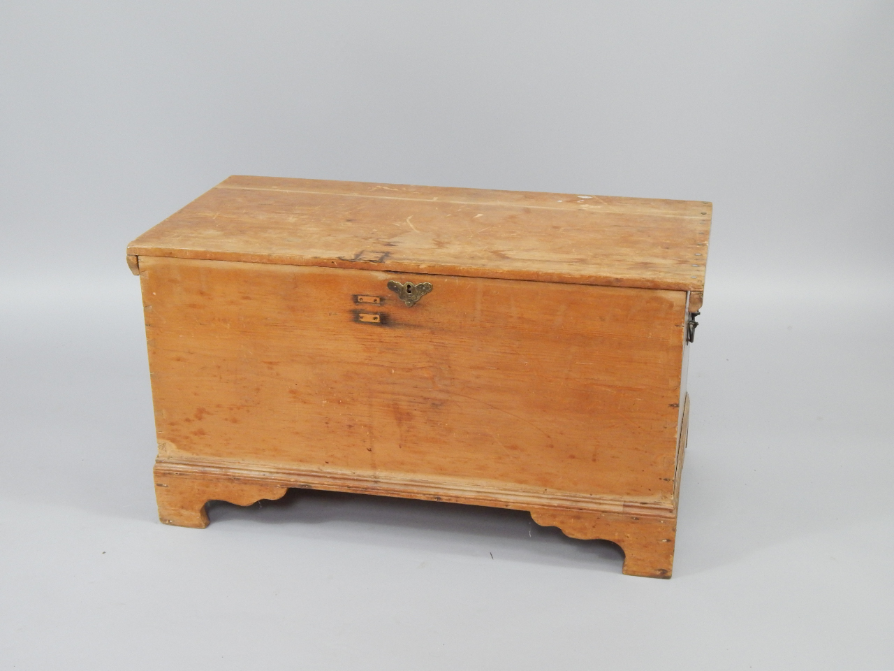 Appraisal: A pine chest with brass lock plate raised on bracket