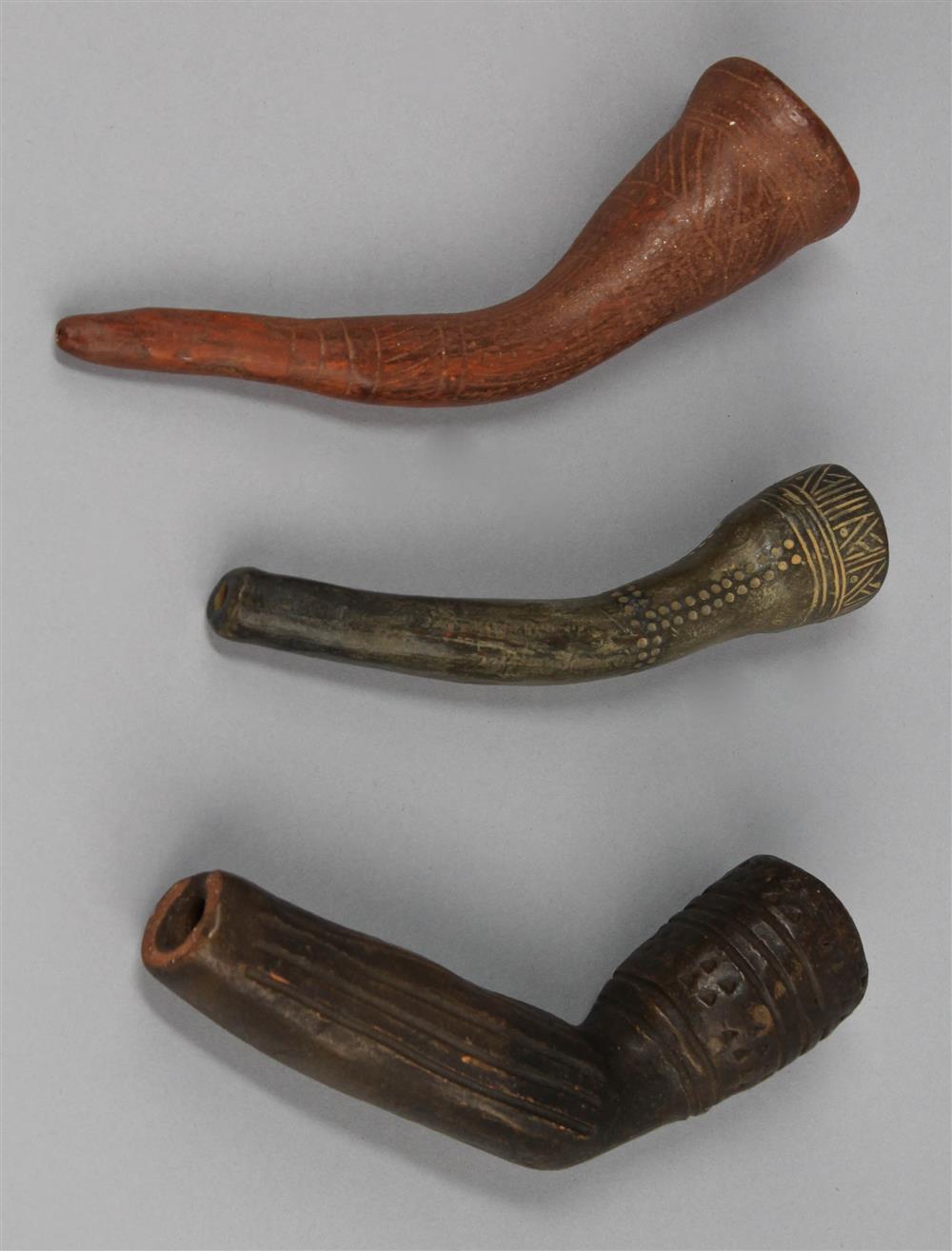 Appraisal: THREE IROQUOIS TYPE CLAY TUBE PIPES th C reproductions length