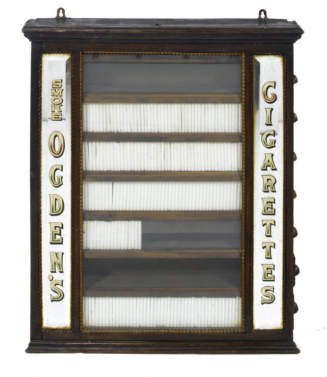 Appraisal: SMOKING A MAHOGANY CIGARETTE VENDING CABINET the glazed front still