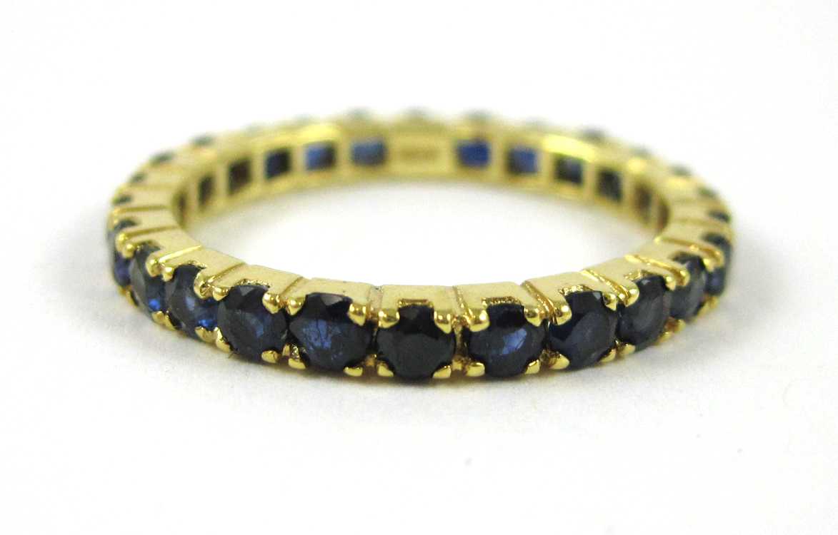 Appraisal: SAPPHIRE AND FOURTEEN KARAT GOLD ETERNITY RING The yellow gold