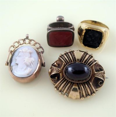 Appraisal: A Victorian gold brooch set on oval garnet cabochon with