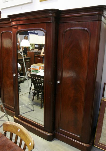 Appraisal: A Victorian mahogany breakfront wardrobe with a central mirrored door