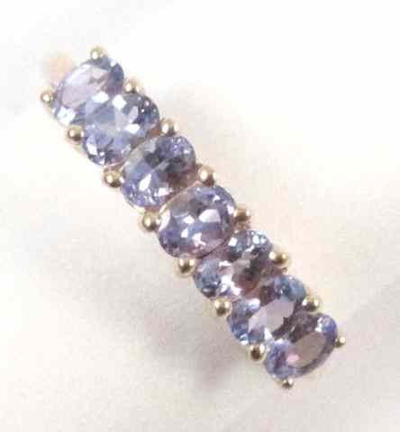 Appraisal: TANZANITE AND FOURTEEN KARAT GOLD RING set with seven oval-cut