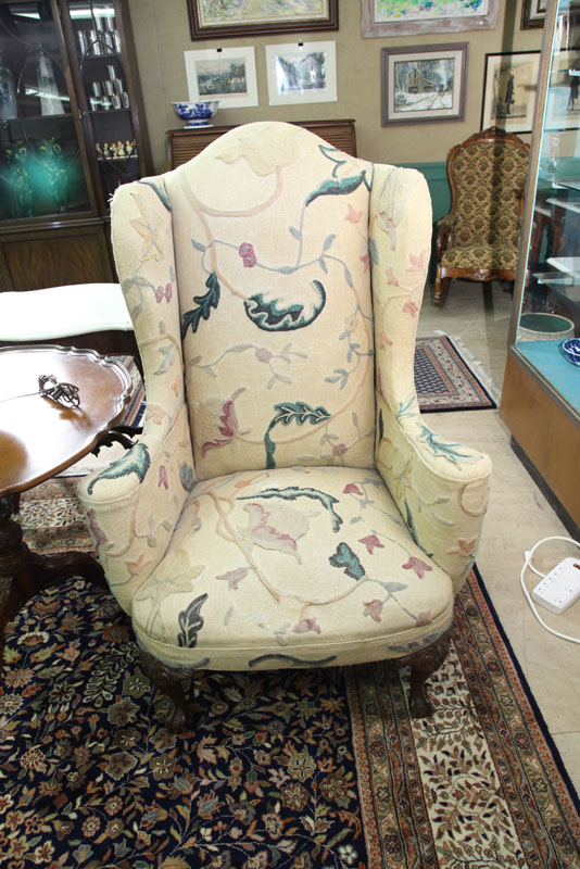 Appraisal: WINGBACK ARMCHAIR Crewel work upholstery resting on carved legs and