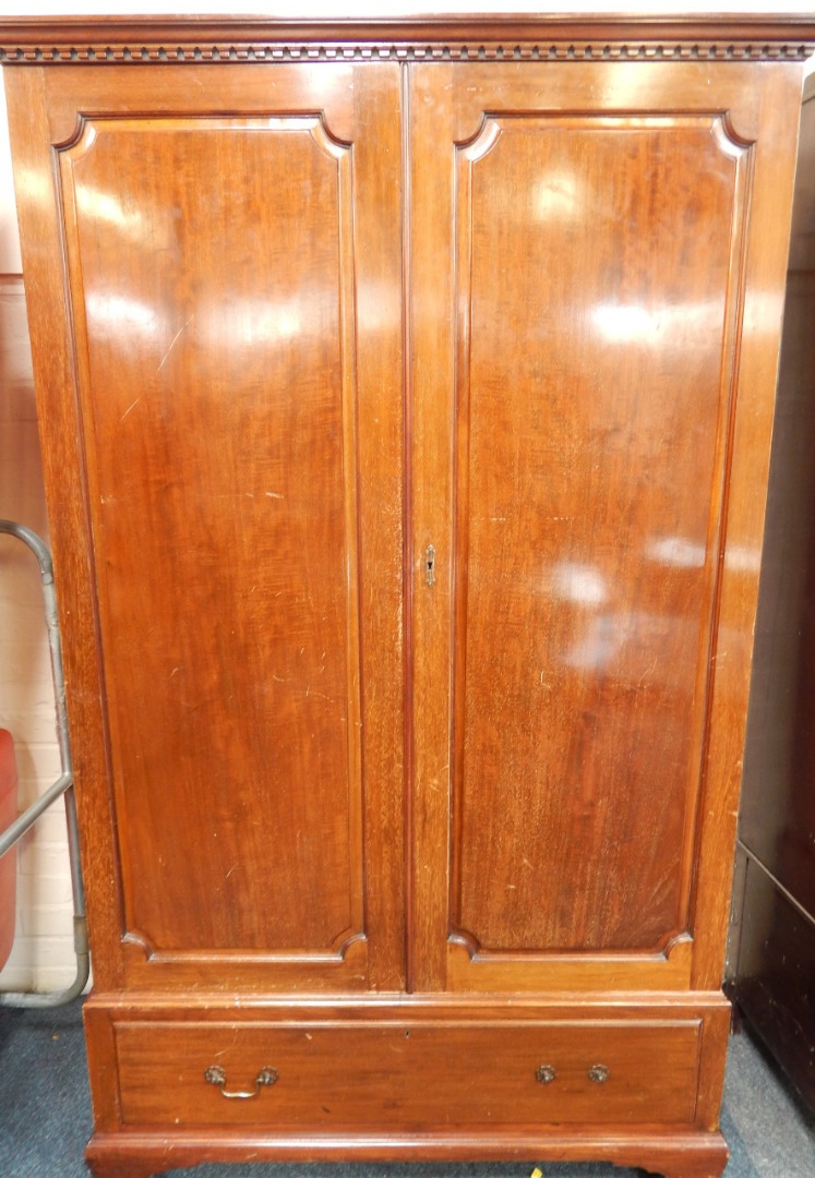 Appraisal: A reproduction mahogany Georgian style hanging single wardrobe with dentil