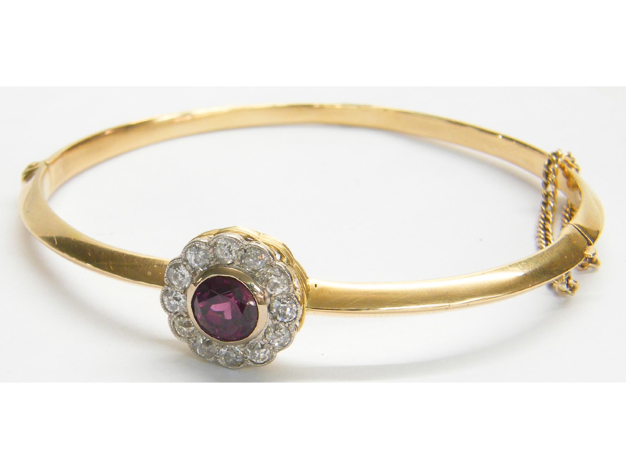 Appraisal: Garnet and diamond yellow gold bangle with a circular cluster