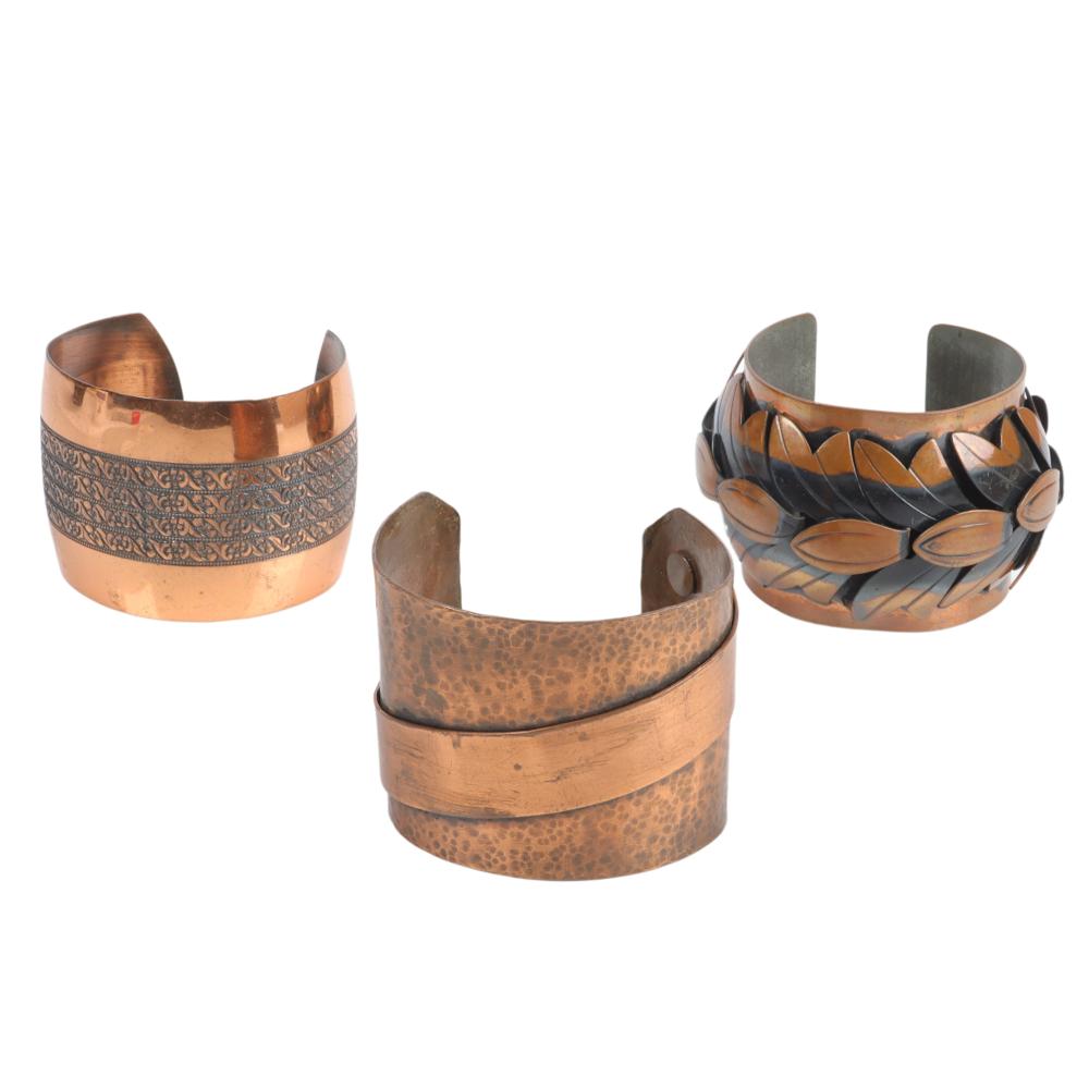 Appraisal: THREE WIDE COPPER CUFFS WITH APPLIED AND TOOLED DESIGNS ONE