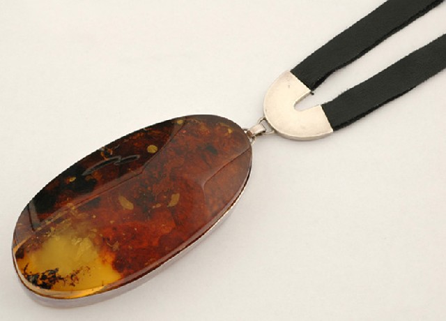 Appraisal: An amber pendant The large oval amber pendant in sterling