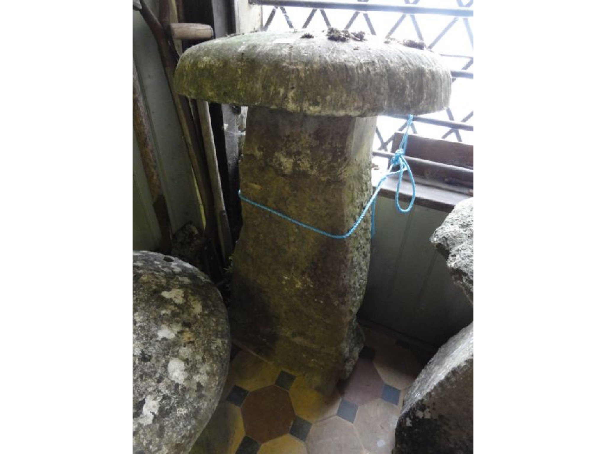 Appraisal: A tall staddle stone with natural stone base beneath a