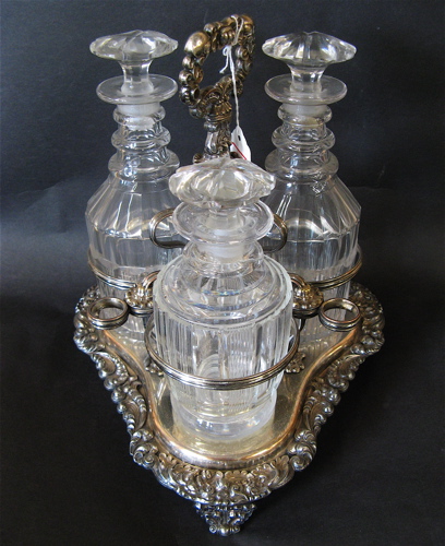 Appraisal: AN ENGLISH SILVER PLATED THREE-BOTTLE TANTALUS containing a pair of