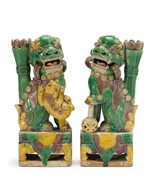 Appraisal: A pair of three-color glazed porcelain fu lions th Century