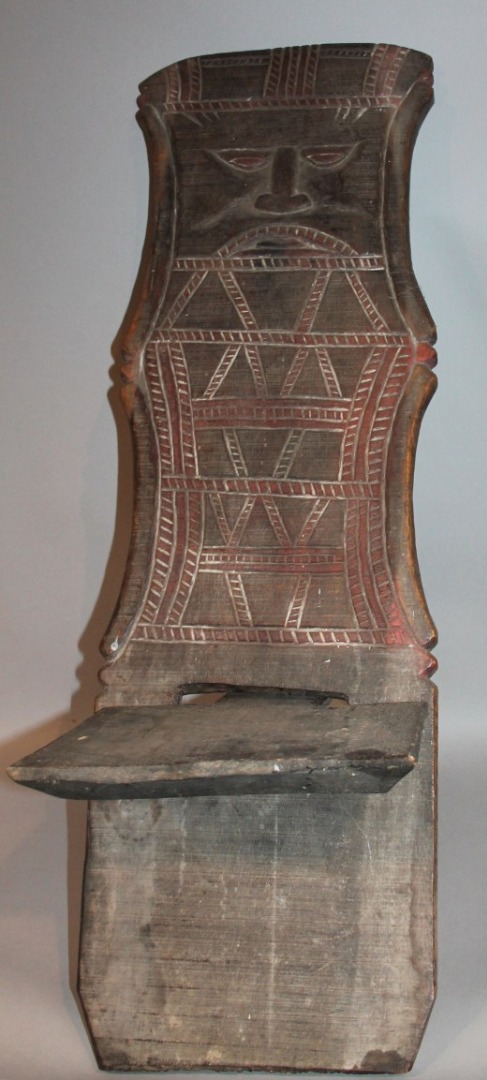 Appraisal: An African tribal panel or seat the inverted back heavily