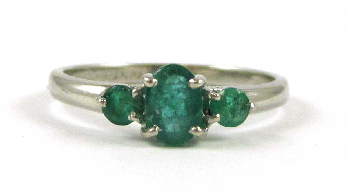 Appraisal: EMERALD AND PLATINUM THREE-STONE RING set with two round-cut emeralds