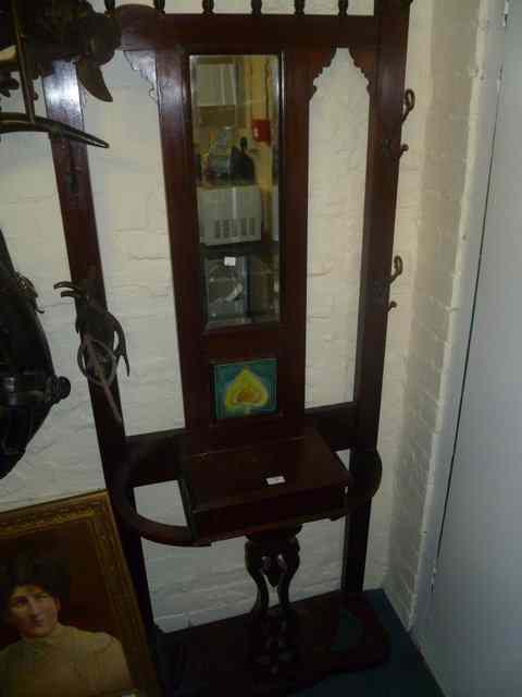 Appraisal: AN EDWARDIAN WALNUT HALL STAND with central mirror panel and