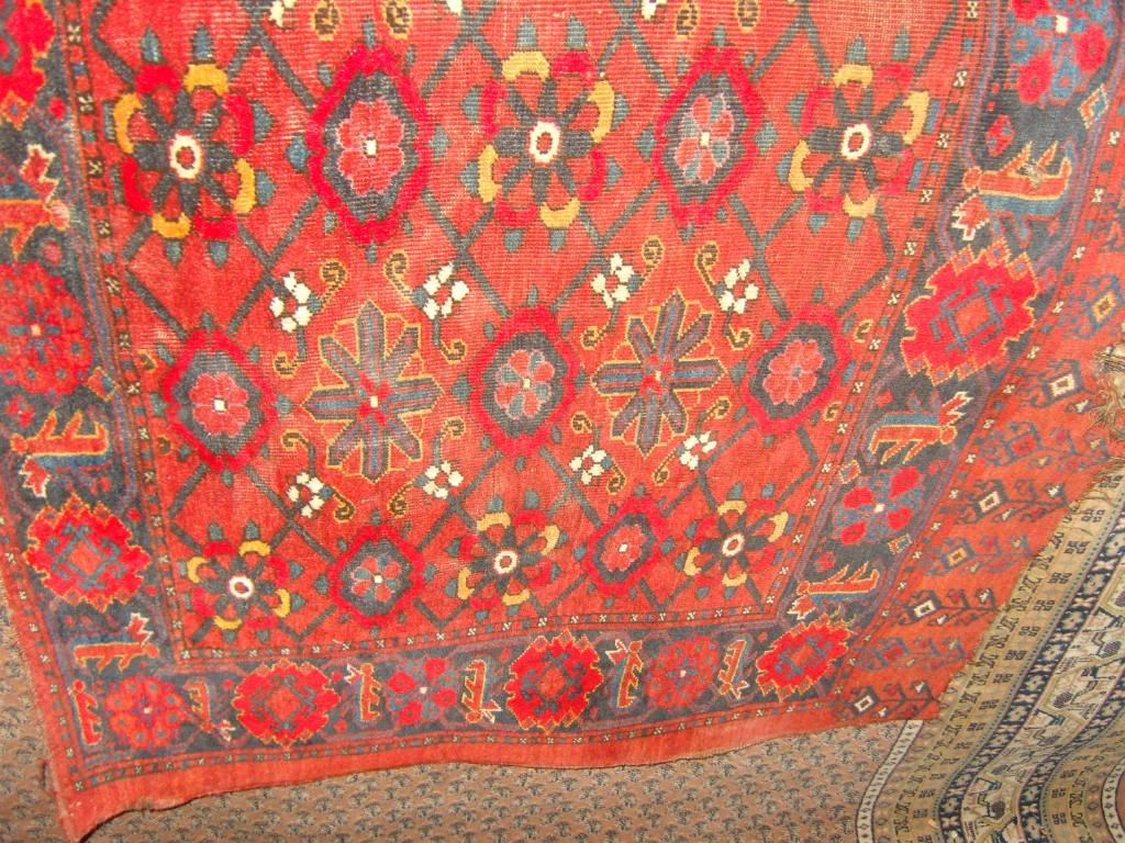 Appraisal: An eastern red ground wool rug with repeating stylised floral