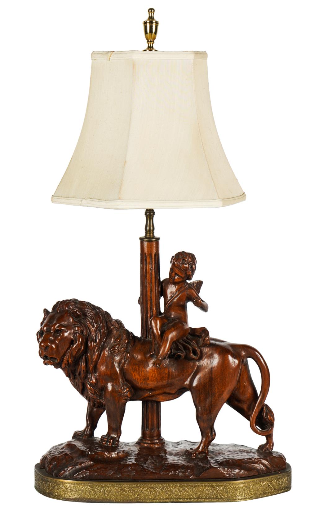 Appraisal: CARVED WOOD TABLE LAMPdepicting a cherub riding a lion mounted