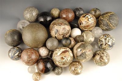 Appraisal: A collection of thirty stone marbled and crystal spheres in