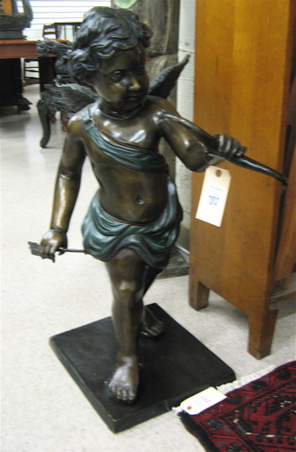 Appraisal: PATINATED BRONZE SCULPTURE cupid in walking pose brown patination with