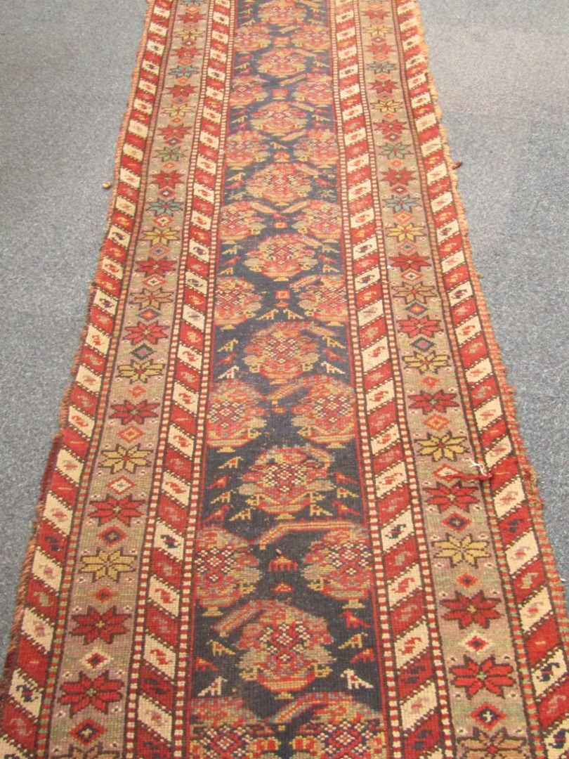 Appraisal: A Caucasian runner decorated with floral geometric motifs against a