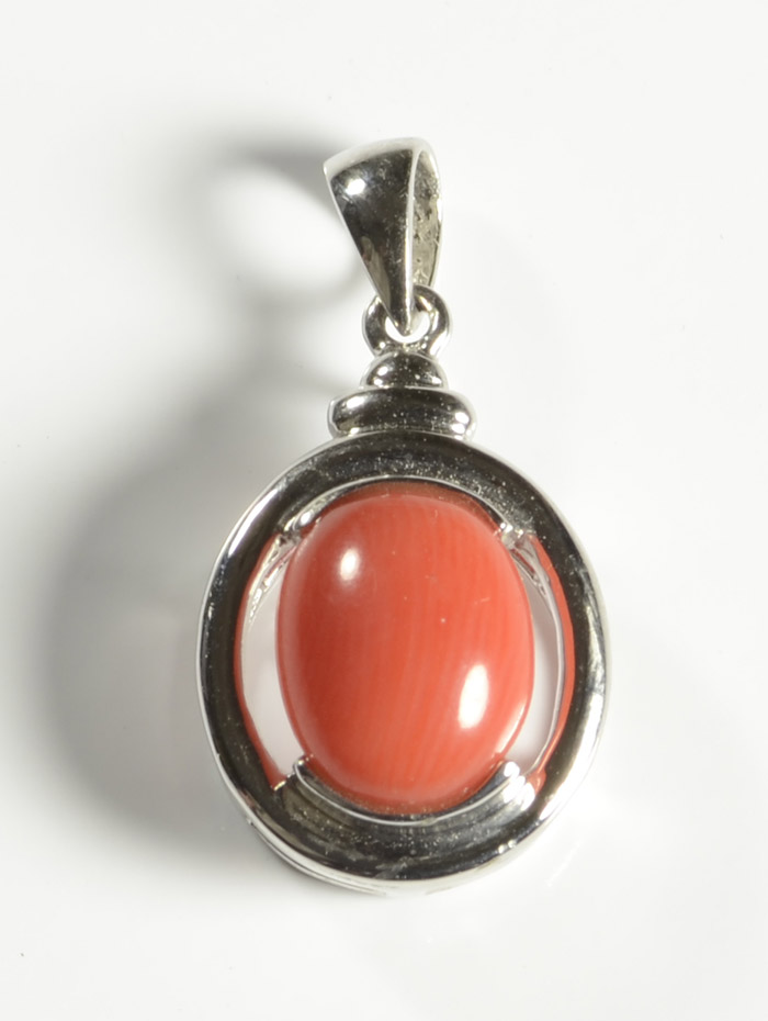 Appraisal: CORAL AND FOURTEEN KARAT WHITE GOLD PENDANT set with a