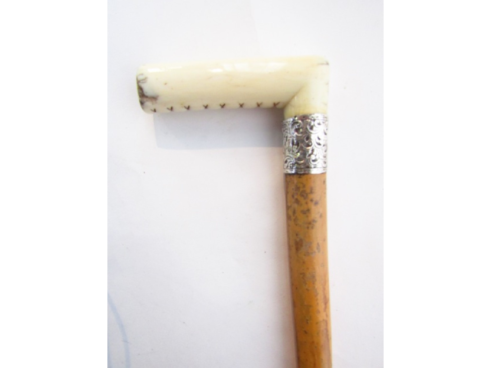 Appraisal: An antique Malacca walking cane terminating in a worked ivory