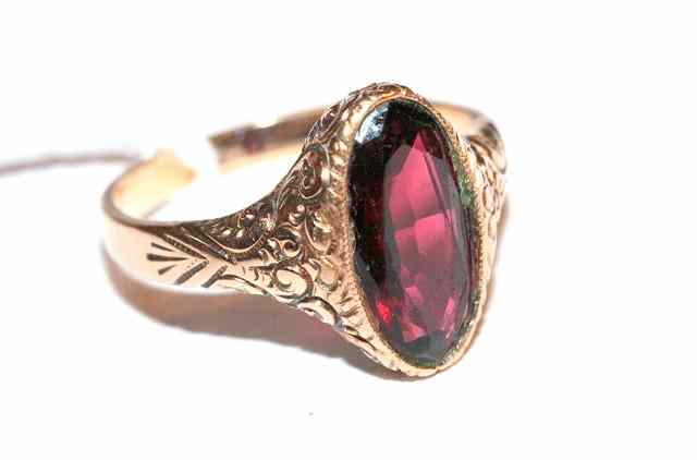 Appraisal: A SINGLE STONE GARNET DRESS RING oval facet cut stone