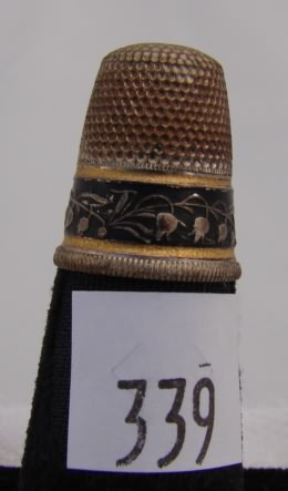 Appraisal: Silver tone thimble with black band with gilt vine design