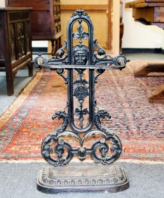 Appraisal: A cast iron umbrella stand with foliate and mask decoration