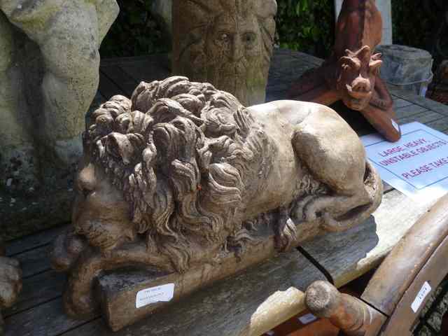 Appraisal: A NEAR PAIR OF COMPOSITE STONE LIONS each in length