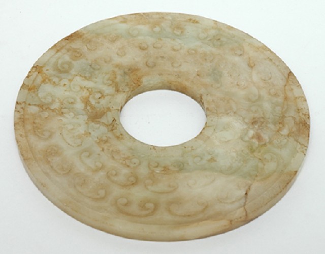 Appraisal: AN ARCHAISTIC CHINESE JADE BI DISC One side carved with