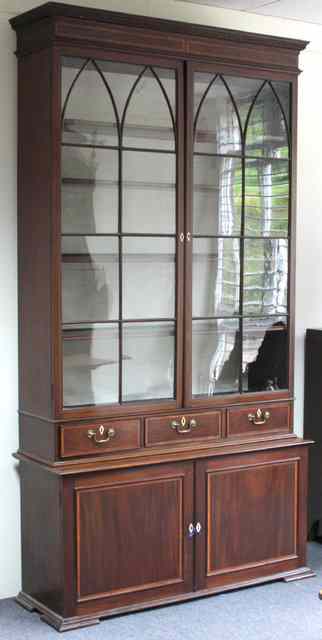 Appraisal: A mahogany display cabinet with pediment above glazed doors and