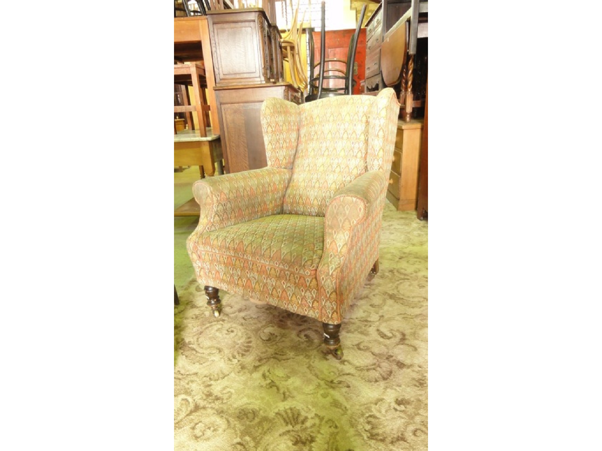 Appraisal: A late Victorian Edwardian wing armchair with shaped outline upholstered