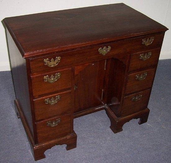 Appraisal: A George II mahogany kneehole pedestal writing desk with long