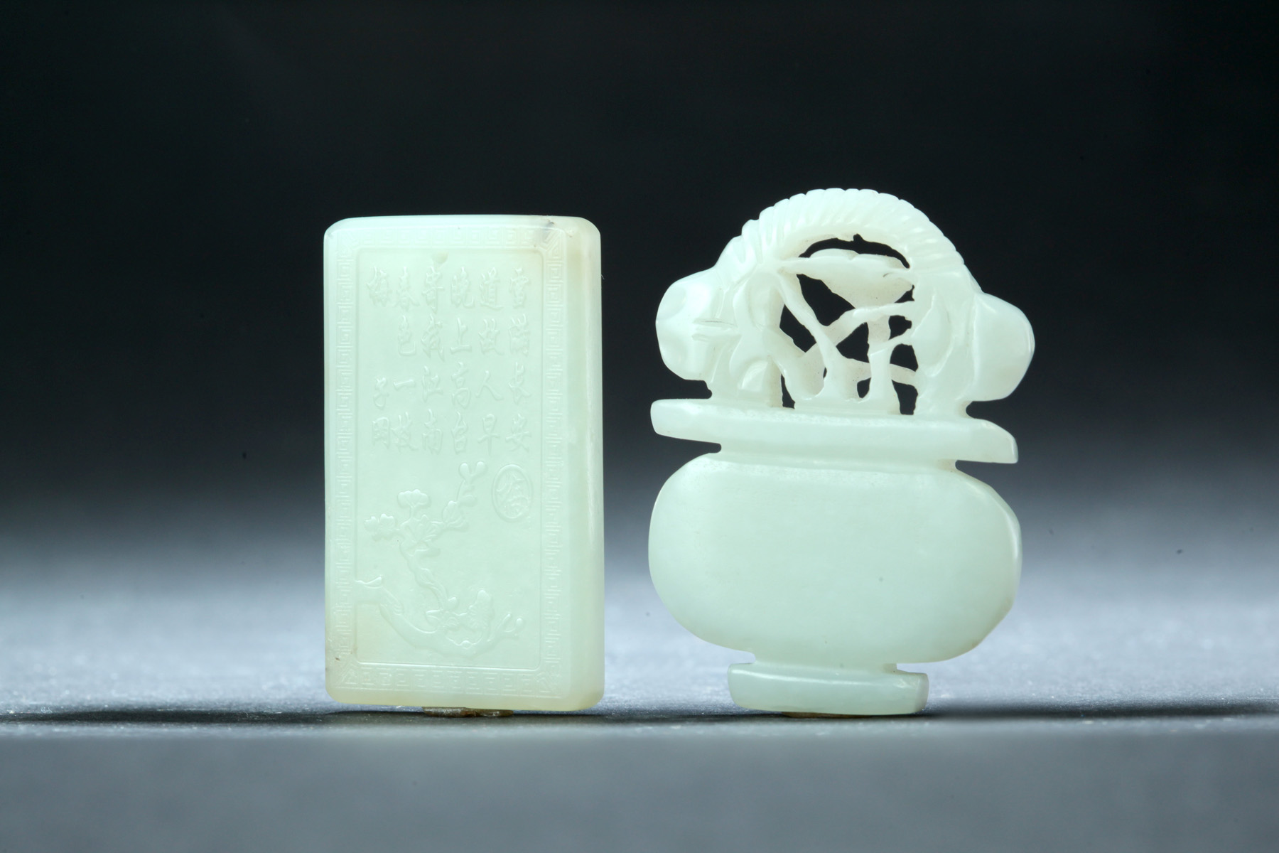 Appraisal: TWO CARVED JADE PENDANTS China th century Rectangle shaped with